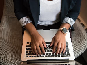 Manos teclando un portátil buscando una gestoría online en Madrid